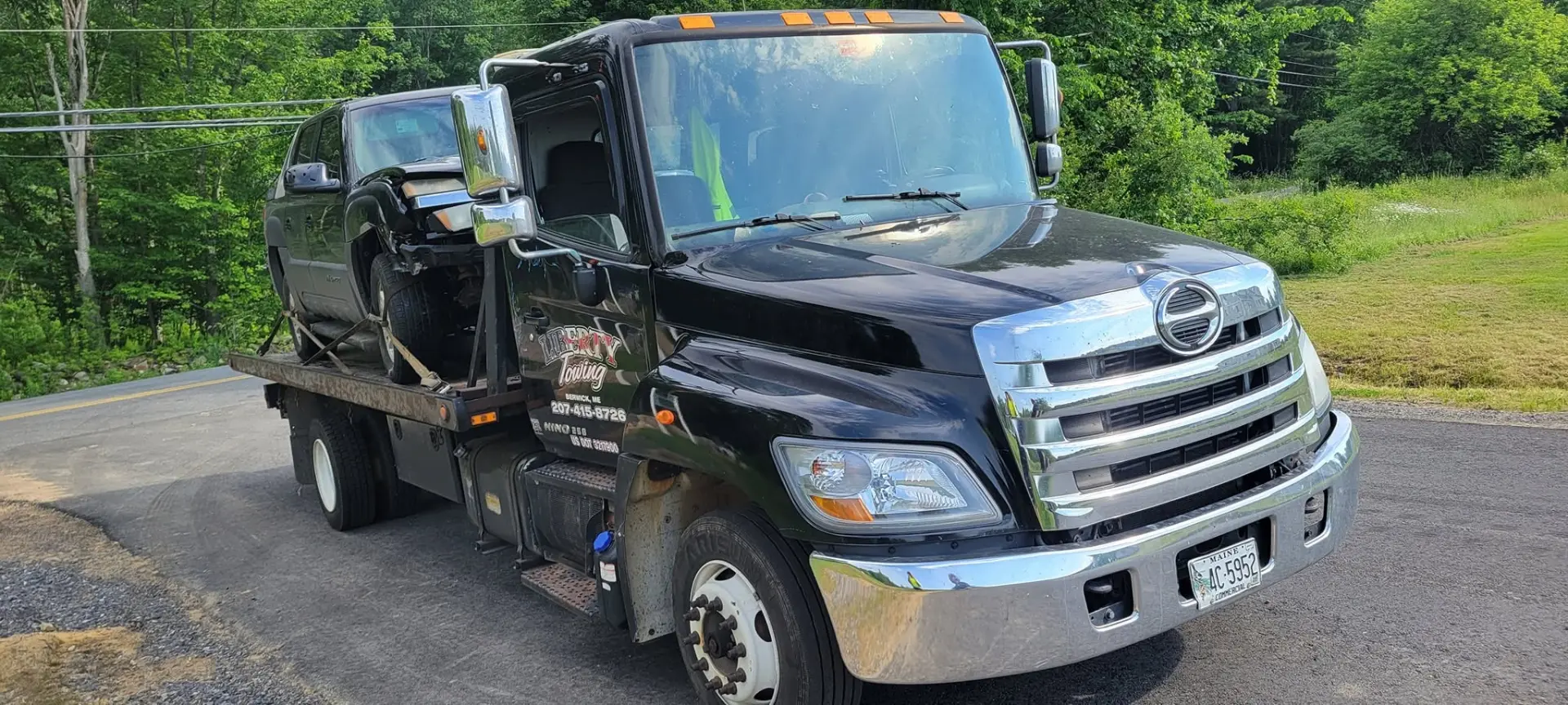 Liberty Towing flatbed truck transporting a vehicle in Southern Maine